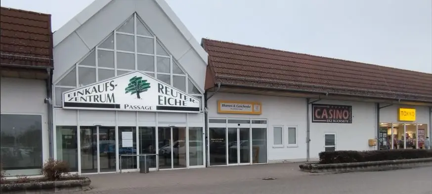 Das Einkaufszentrum Reuter Eiche in Stavenhagen zeigt mehrere Ladenfronten mit den Schildern Einkaufszentrum Passage, Casino und Takko.