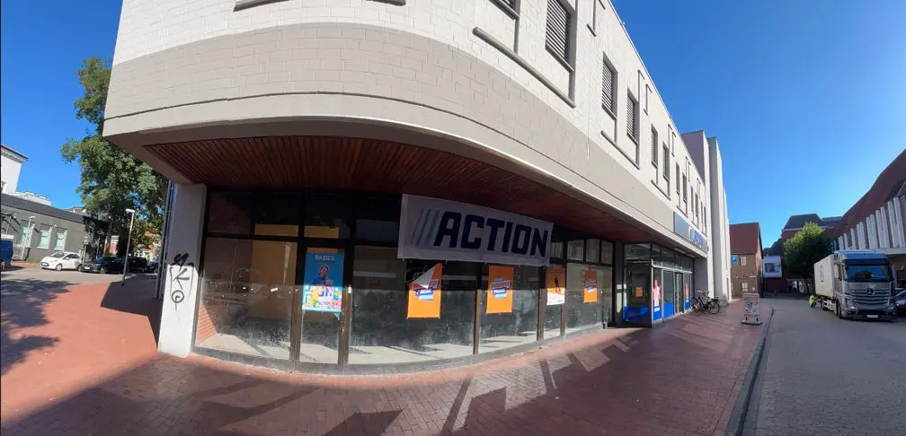 A corner retail building in Minden shows large ACTION signage across the windows on a sunny street.